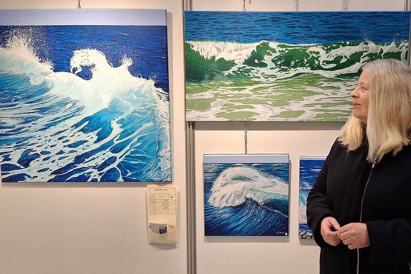 vagues de Sylvie Guével Photo de Sylvie Guével devant ses tableaux de vagues